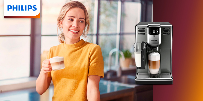 Devojka u kuhinji pored Philips aparata za espresso u ruci drži šoljicu sveže pripremljene kafe
