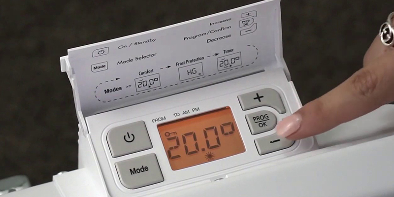 Devojka prstom podešava temperaturu na Noirot panelnom radijatoru putem digitalnog termostata