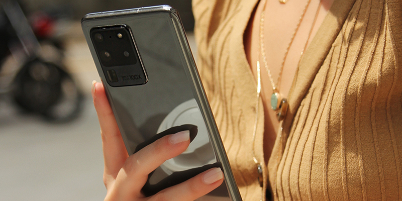 Mlada i elegantna devojka u ruci drži Samsung Galaxy S20 mobilni telefon