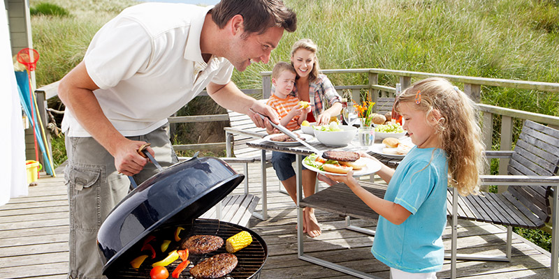 Na terasi u vikendici porodica sa dvoje dece roštilja na roštilju na ugalj