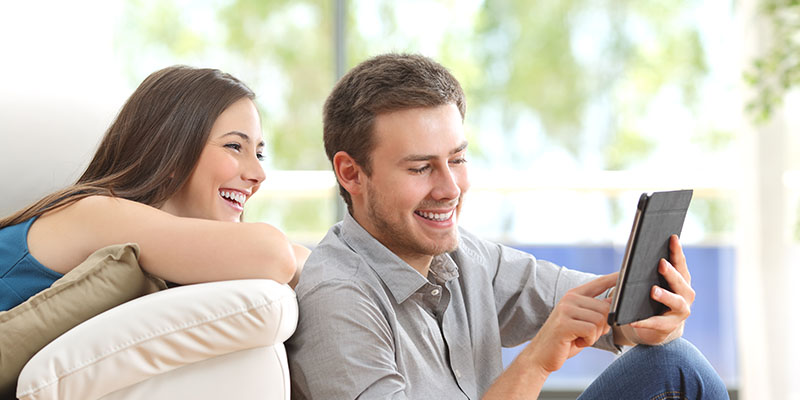 Zaljubljeni par uživa u čitanju na elektronskom čitaču knjiga