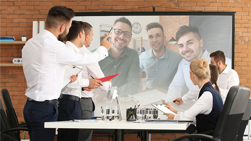 Eleganti zaposleni ovde video konferenciju u kancelariji koristeći projektorsko platno i projektor