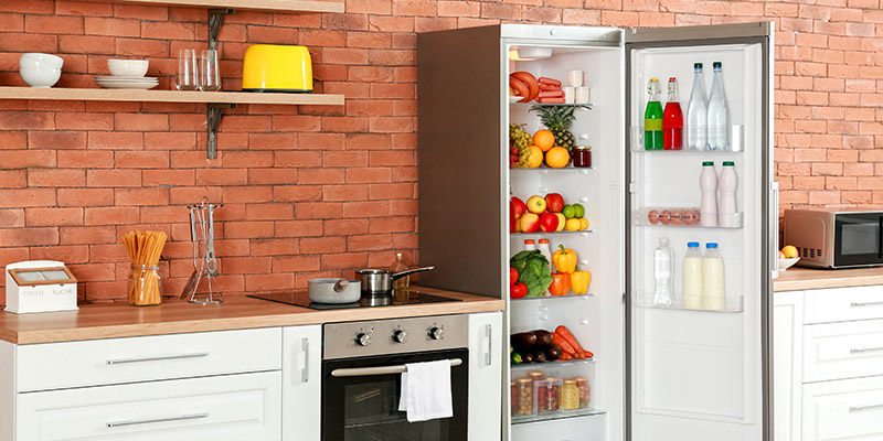 Frižider sa jednim vratima u kuhinji sa otvorenim vratima i policama punim voća