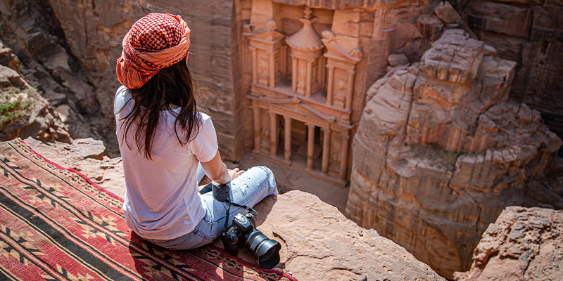 Devojka sa foto-aparatom sedi iznad veličanstvenog prizora drevnog grada