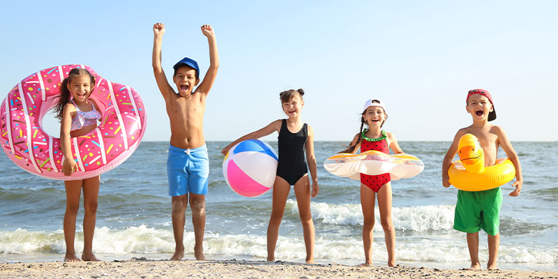 Deca uživaju u igri na plaži uz gume, lopte i ostale igračke na naduvavanje