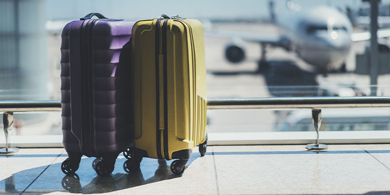 Ljubičasti i žuti koferi za putovanje na aerodromu