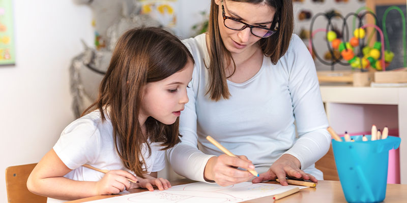 Majka i ćerka olovkom podvlače važne informacije na papiru