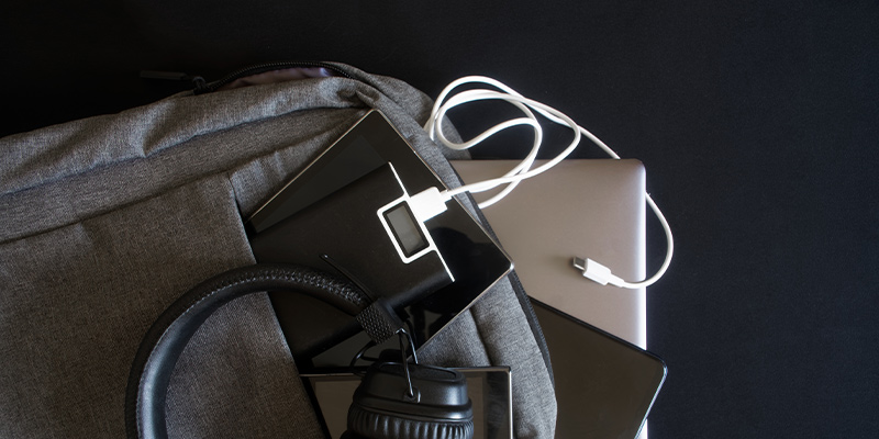 Powebank viri iz torbe - pored su tablet, laptop, slušalice